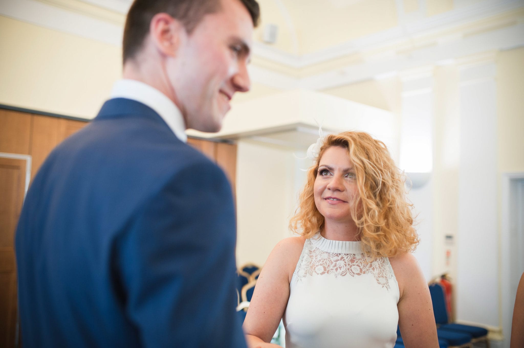 bride and groom Bromley on Bow Registry office, London UK Wedding photography ceremony room with the guest ring exchange