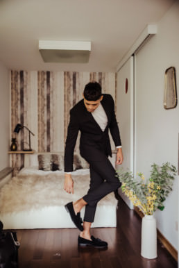 Groom wearing balck suit and white trutle neck,