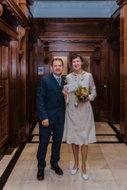 Katya in silk vintage weddign dress, Brett in blue suit at the Old Marylebone registry office London marriage certificate ceremony
