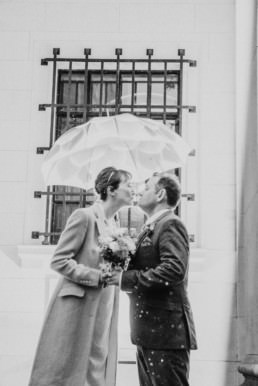 Katya in silk vintage weddign dress, Brett in blue suit at the Old Marylebone registry office London couples shot at the entrance