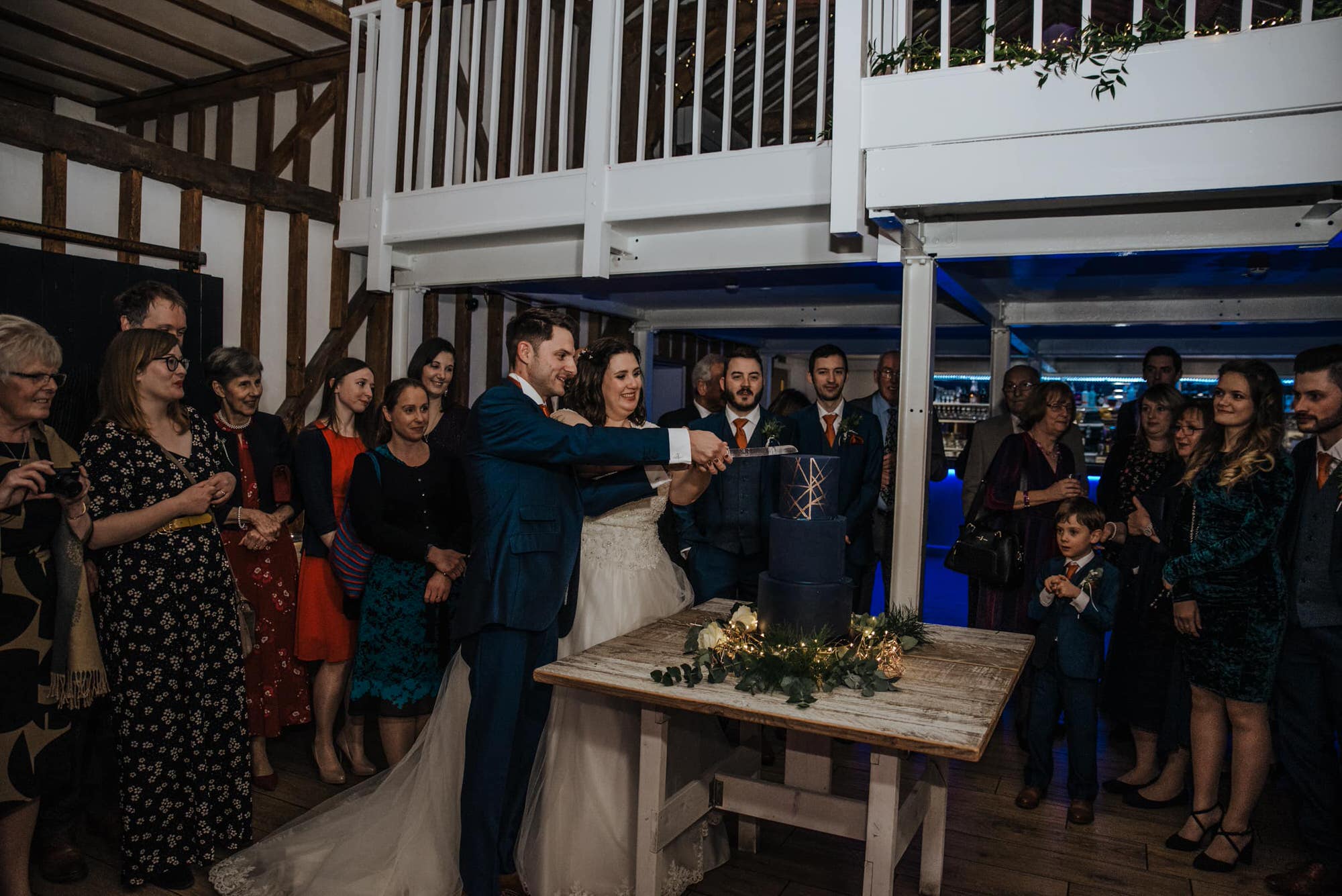 Cake cutting the bride ad groom at the reception Roshni photography The Milling Barn, Bluntswood Hall, Throcking wedding photographer