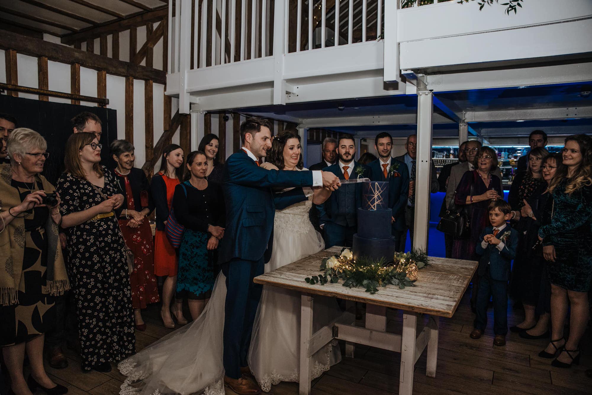 Cake cutting the bride ad groom at the reception Roshni photography The Milling Barn, Bluntswood Hall, Throcking wedding photographer