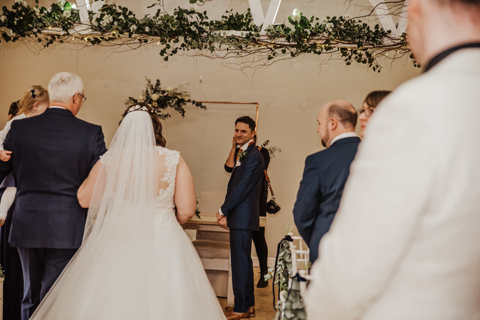 Wedding ceremony, bride in white walking down to the groom Roshni photography The Milling Barn, Bluntswood Hall, Throcking wedding photographer