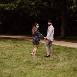Couple looking back near a river at the Painshill Park Surrey engagement shoot