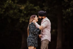 Couple kissing near a river at the Painshill Park Surrey engagement shoot