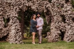 Couple at the sculpture near a river at the Painshill Park Surrey engagement shoot