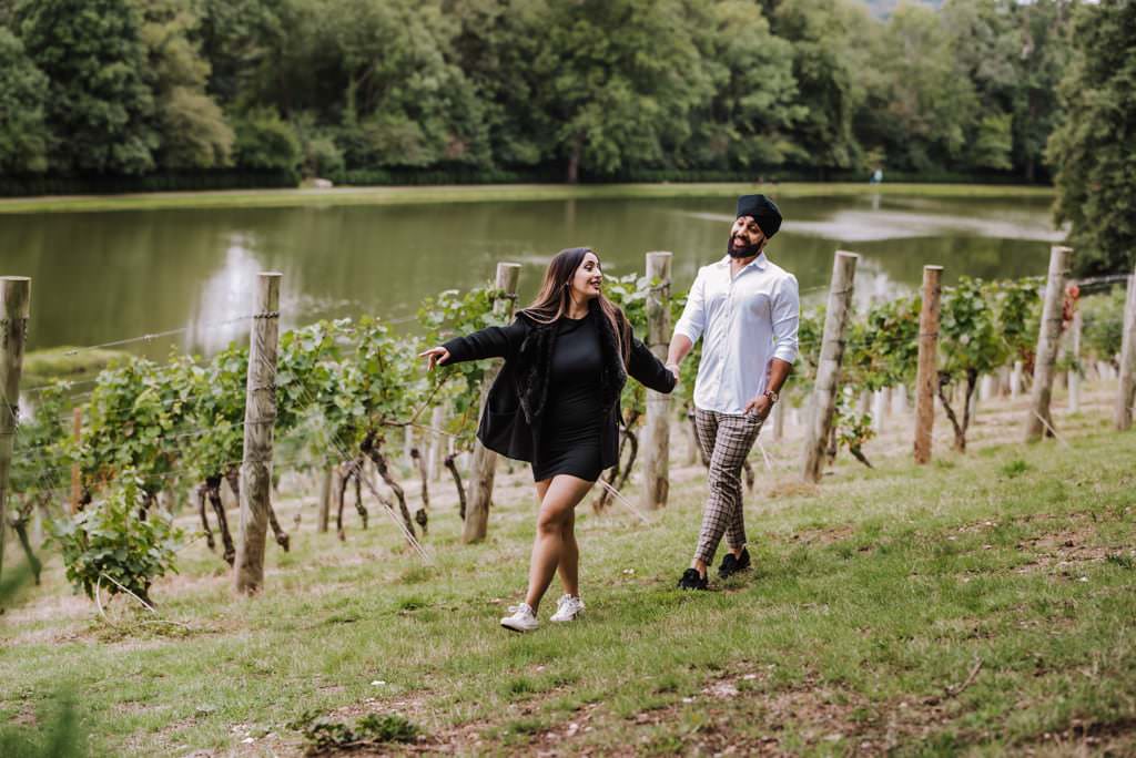 Couple near a river at the Painshill Park Surrey engagement shoot