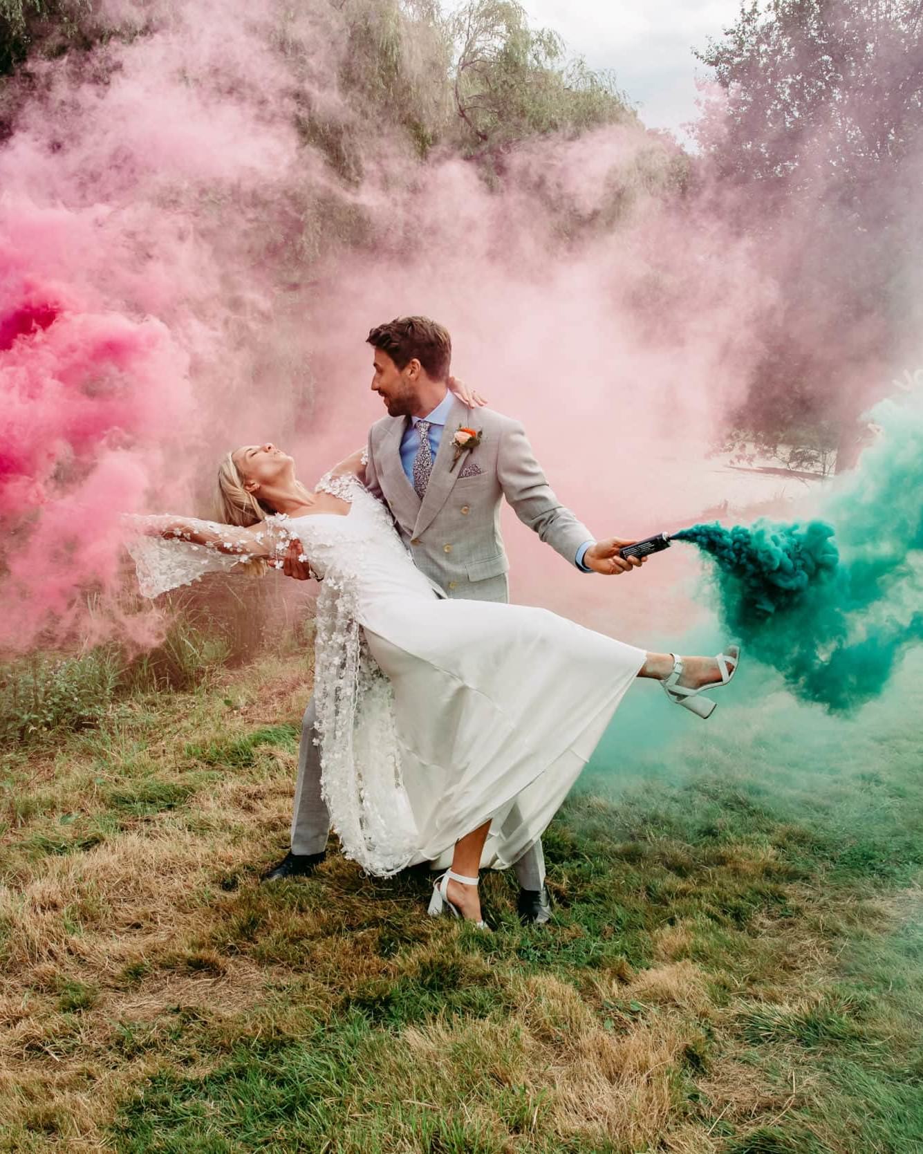 Bride been swept off her sweep, with green and pink smke grenades in their hands