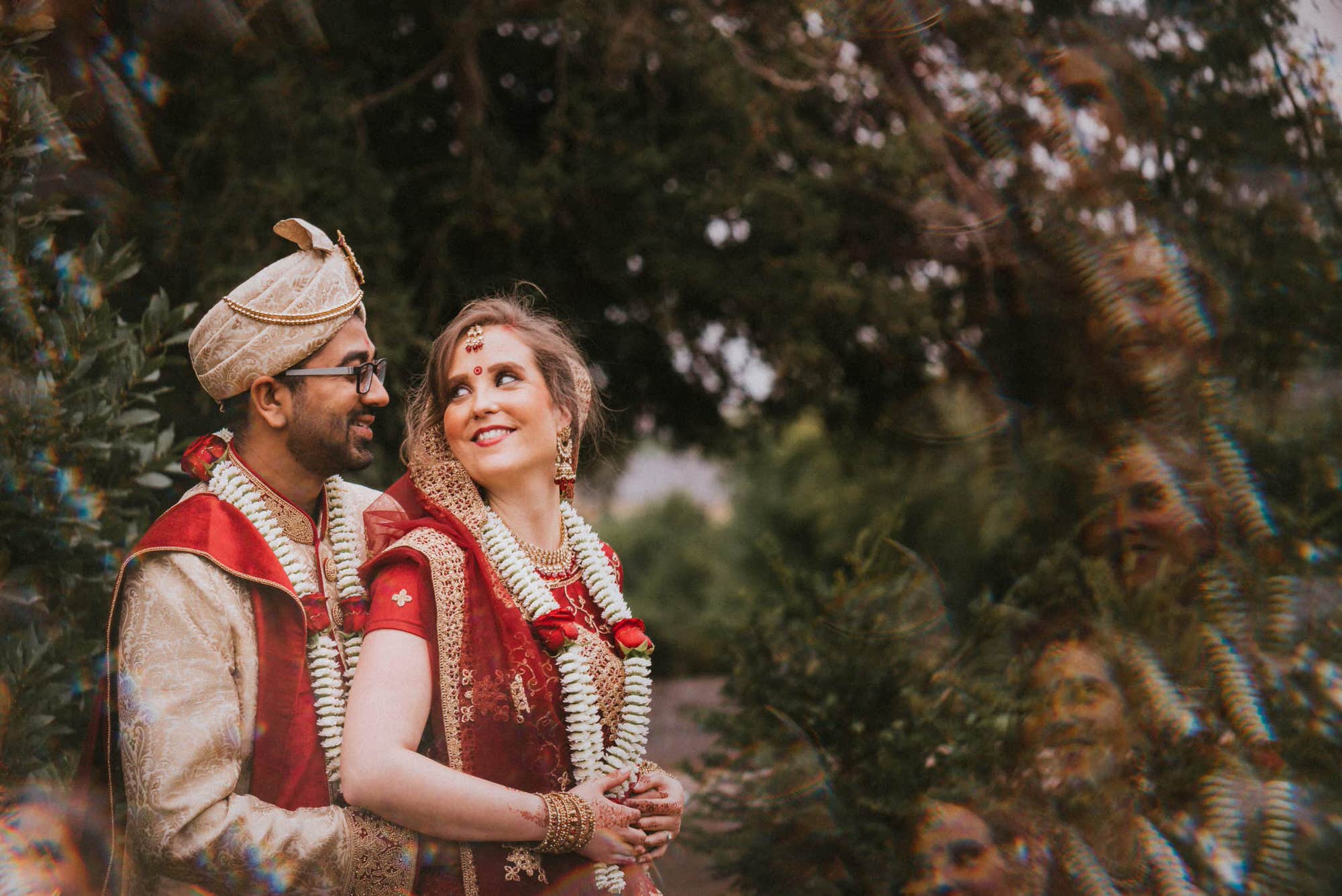 English bride and Indian groom looking at each other for couples portraits