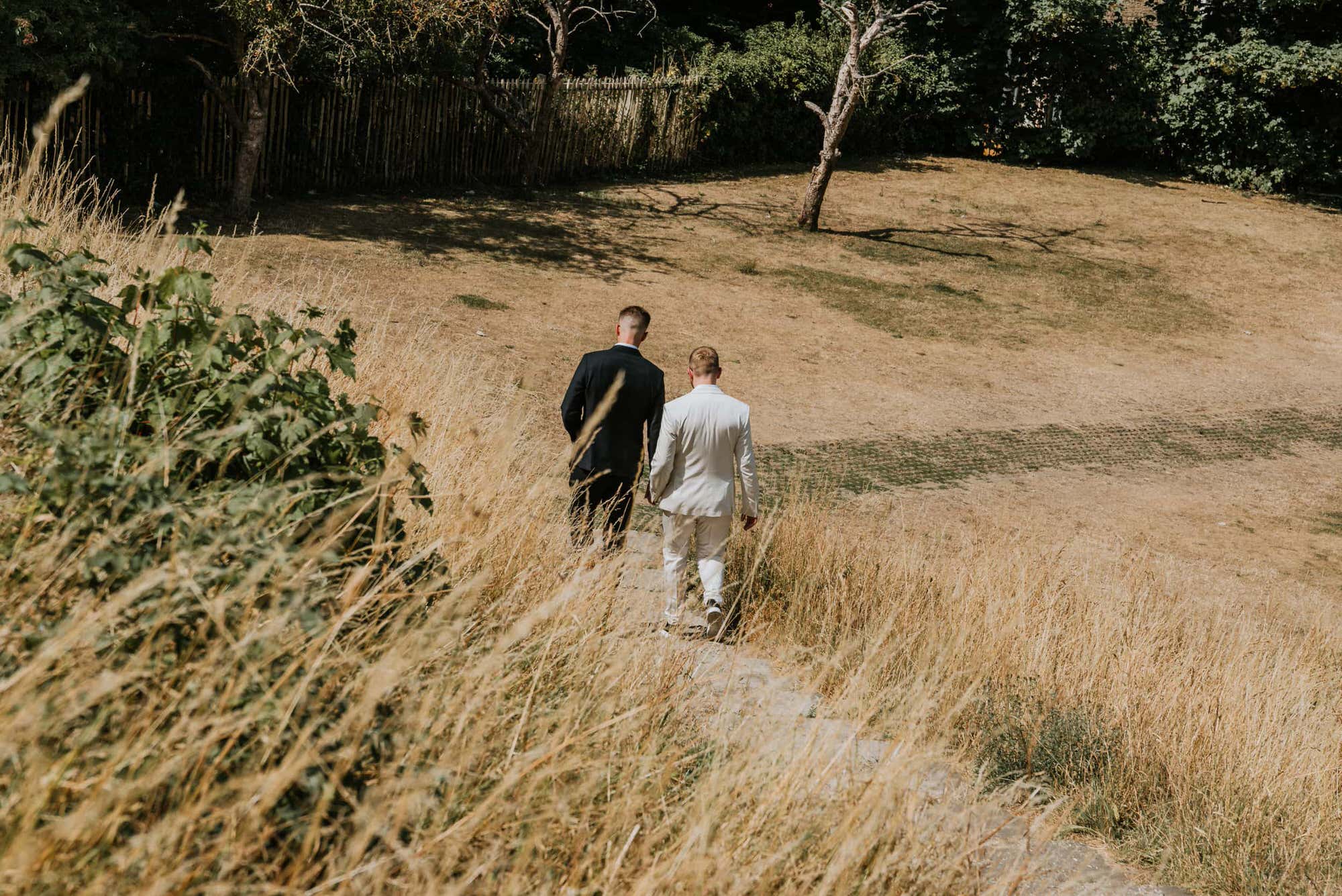 grooms walking down the steps in the field