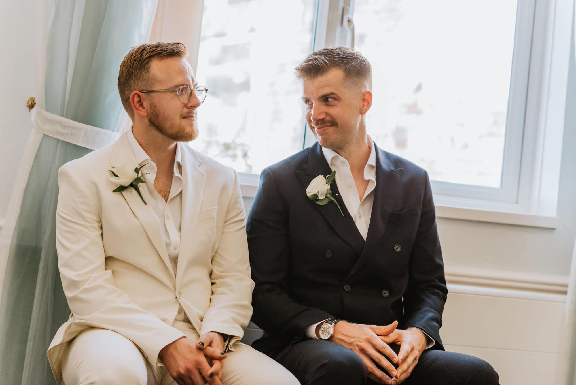 two grooms looking at each other smiling