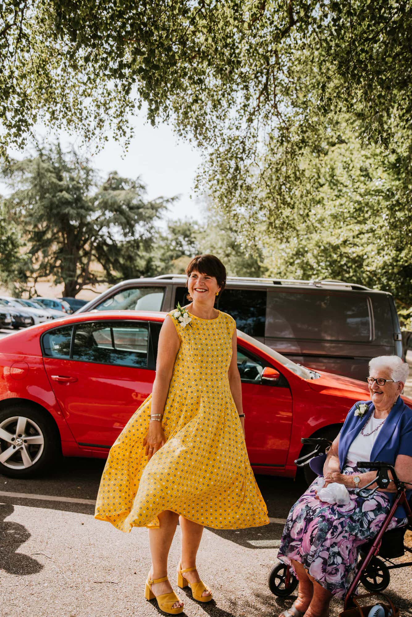 Lady in yellow dress, grandma in seated chair smiling