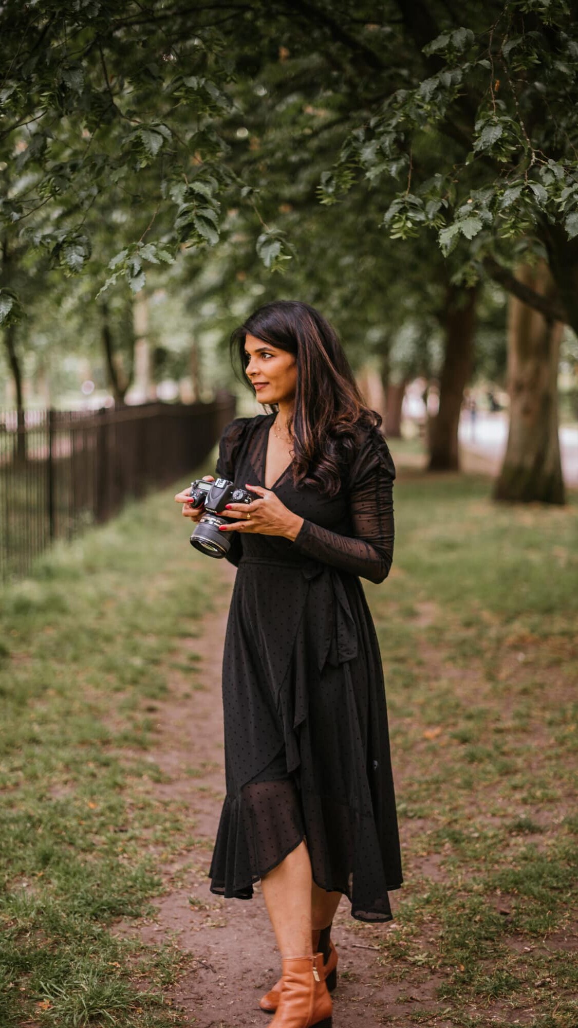 London wedding photographer Headshot in a park wearing blakc dress and holding a Nikon camera